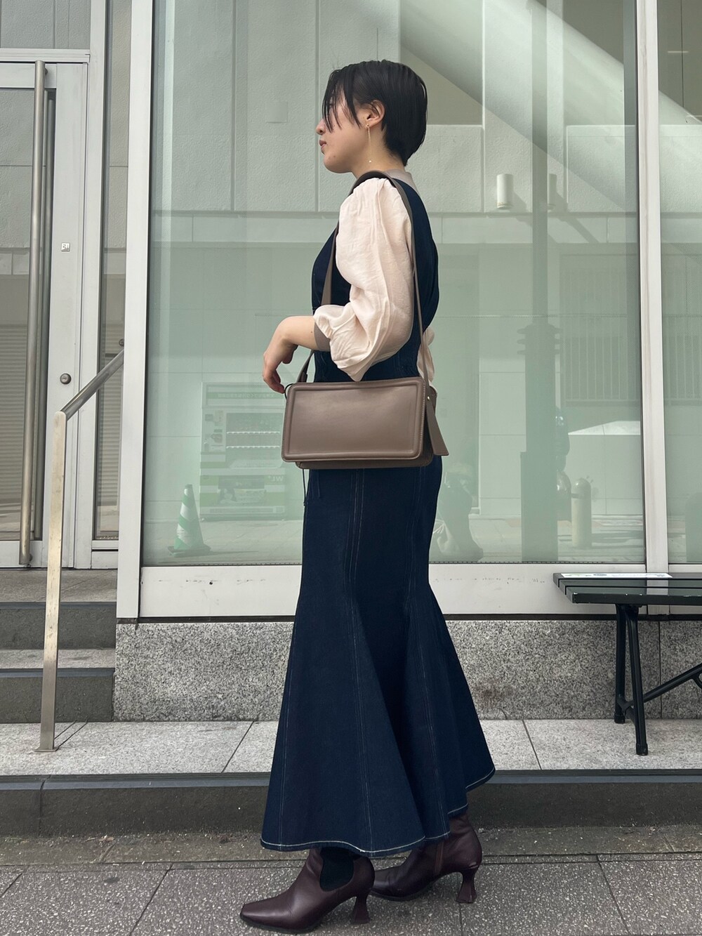 ベージュ系のカーディガン/ボレロ、レッド系のブーツ、ブラウン系のニット/セーターを着用したレディースの冬コーディネートの3枚目の写真