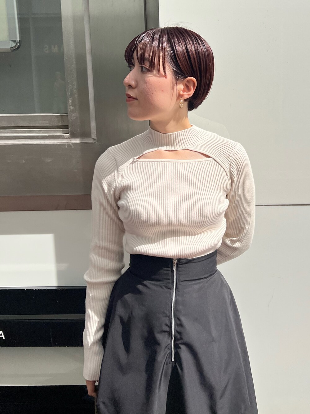 ホワイト系のニット/セーター、ブラック系のブーツ、ブラック系のスカートを着用したレディースの秋コーディネートの4枚目の写真