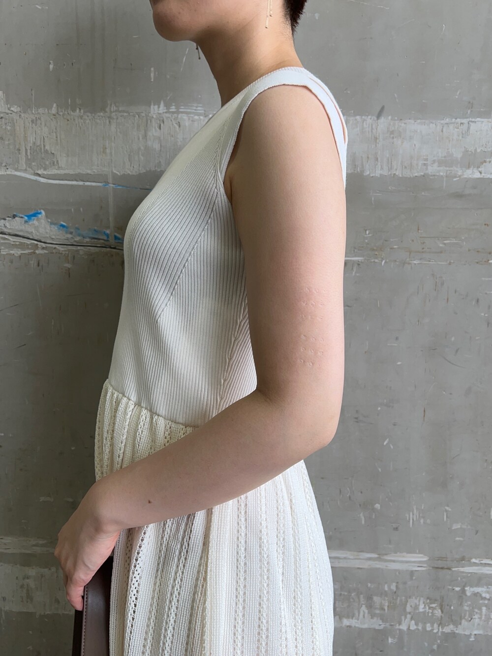 ベージュ系のサンダル、ベージュ系のショルダーバッグ、ホワイト系のワンピースを着用したレディースの夏コーディネートの3枚目の写真