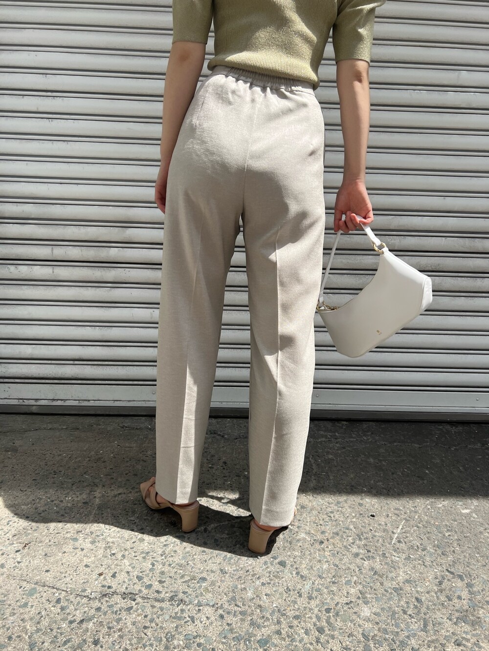 ホワイト系のハンドバッグ、ベージュ系のサンダル、ベージュ系のその他パンツを着用したレディースの春コーディネートの9枚目の写真