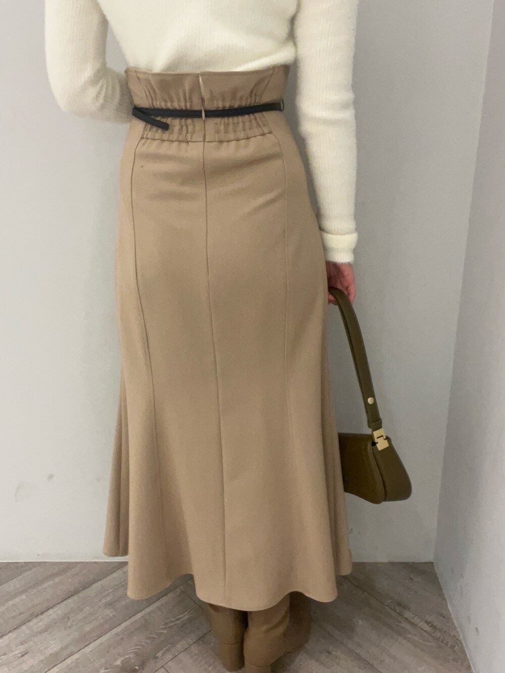 ベージュ系のブーツ、ブラウン系のショルダーバッグ、ベージュ系のスカートを着用したレディースの冬コーディネートの7枚目の写真