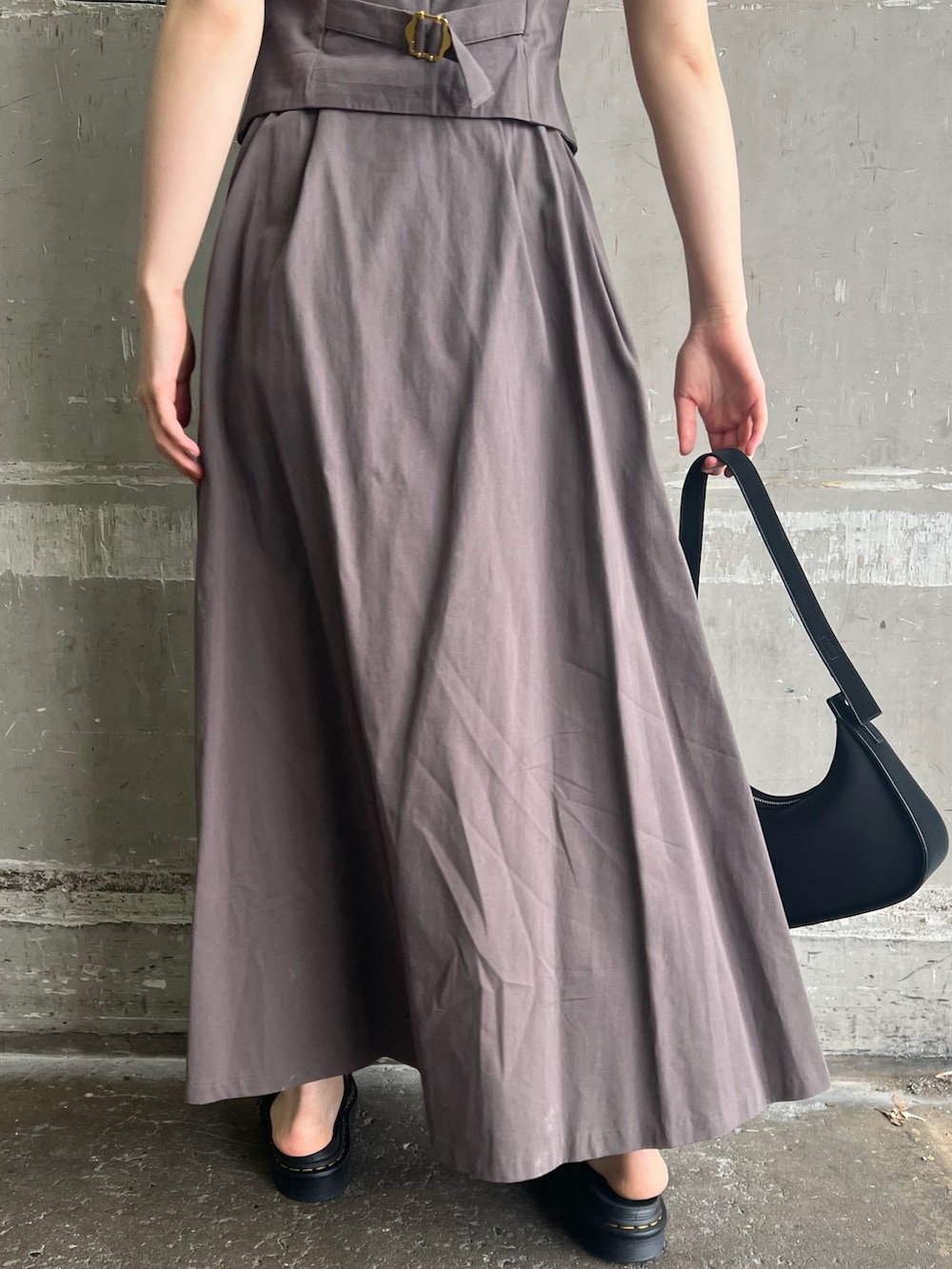 グレー系のワンピース、ブラック系のハンドバッグ、ブラック系のサンダルを着用したレディースの夏コーディネートの8枚目の写真