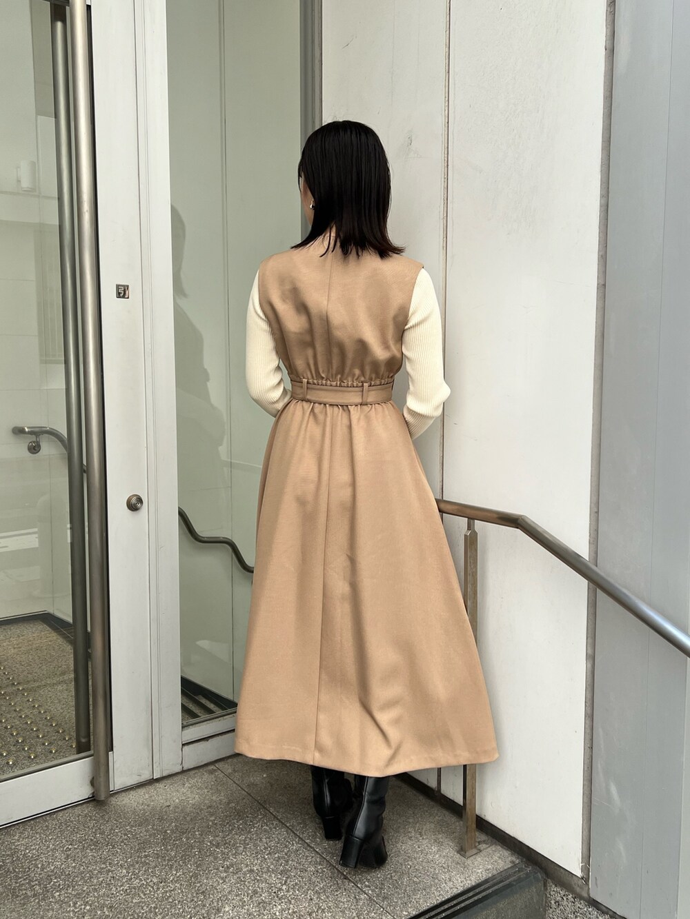 ベージュ系のトレンチコート、ホワイト系のショルダーバッグ、ホワイト系のニット/セーターを着用したレディースの秋コーディネートの7枚目の写真