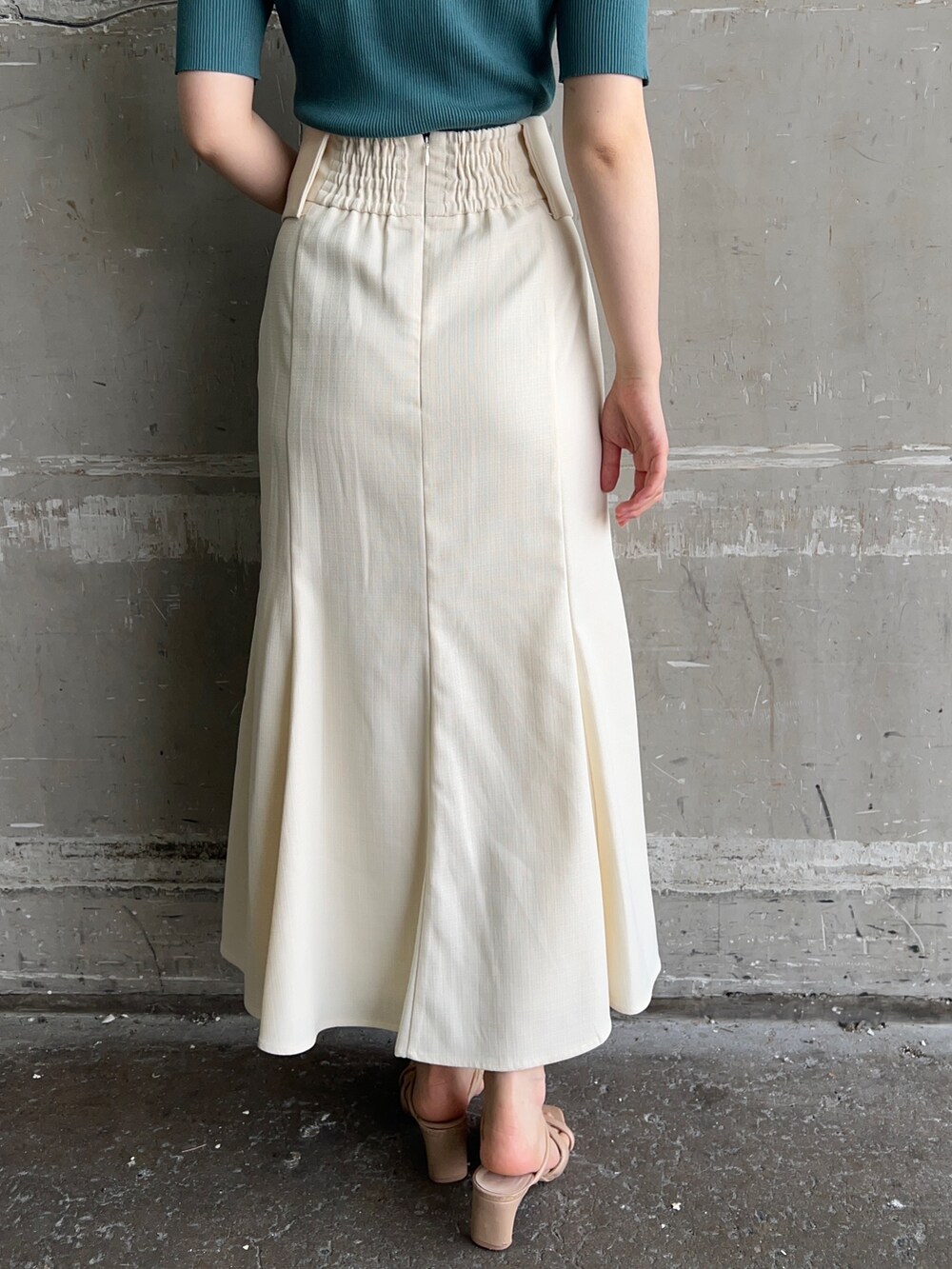 ホワイト系のハンドバッグ、グリーン系のニット/セーター、ホワイト系のスカートを着用したレディースの夏コーディネートの6枚目の写真