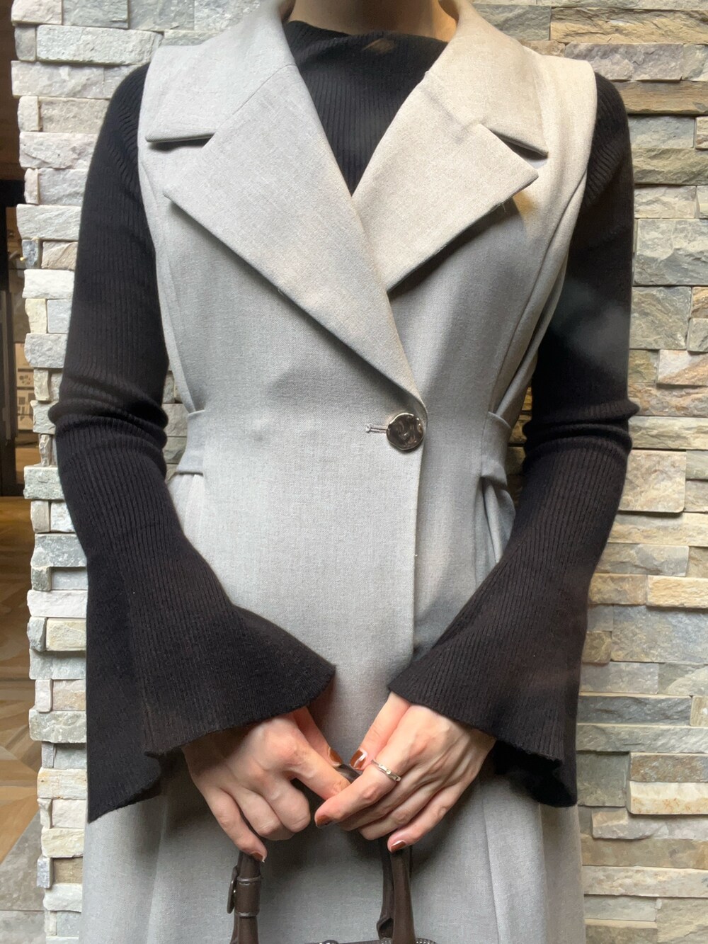 ブラック系のブーツ、ブラック系のニット/セーター、グレー系のワンピースを着用したレディースの秋コーディネートの3枚目の写真