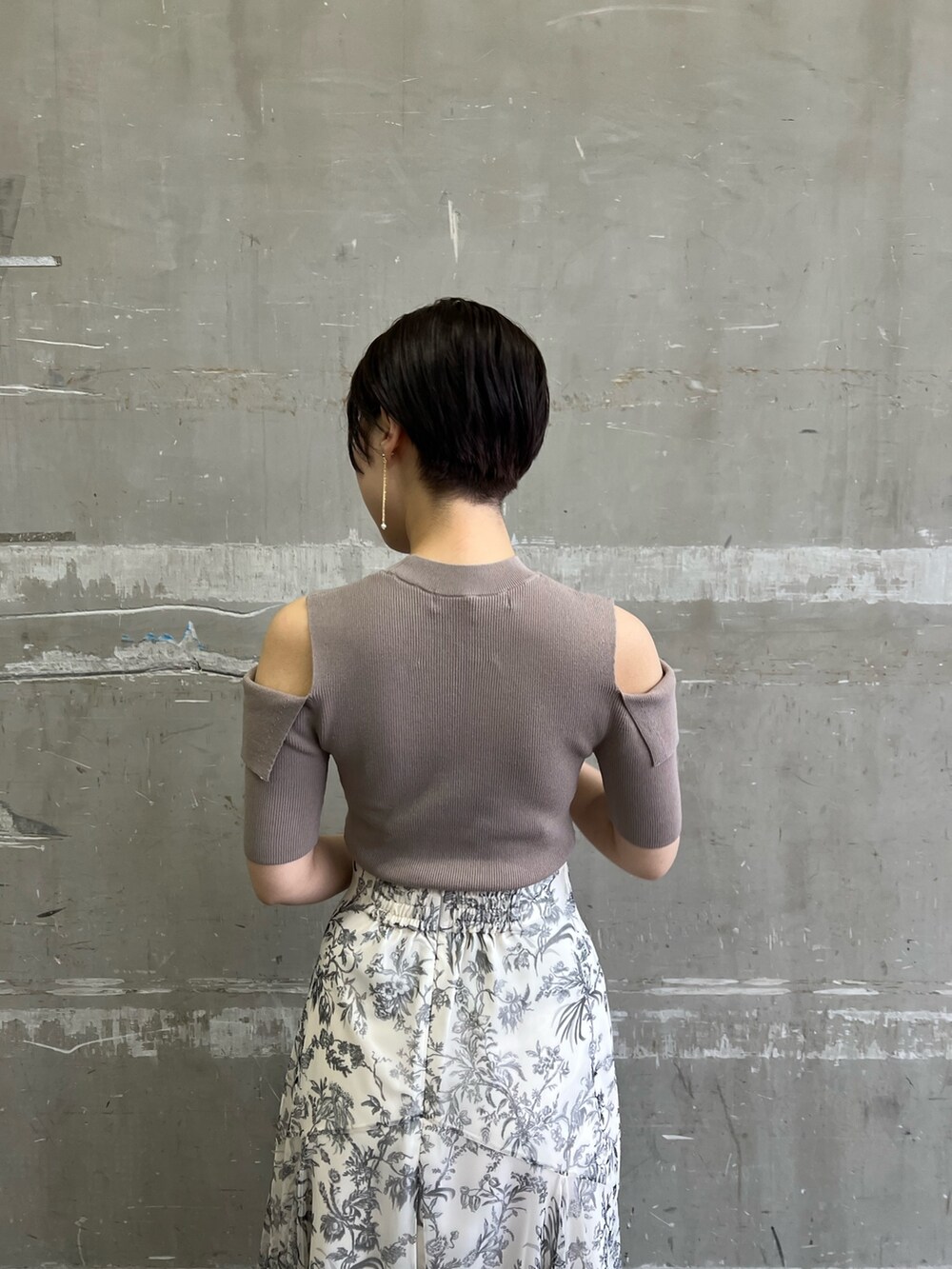 ベージュ系のノーカラーコート、ホワイト系のスカート、ベージュ系のサンダルを着用したレディースの冬コーディネートの7枚目の写真