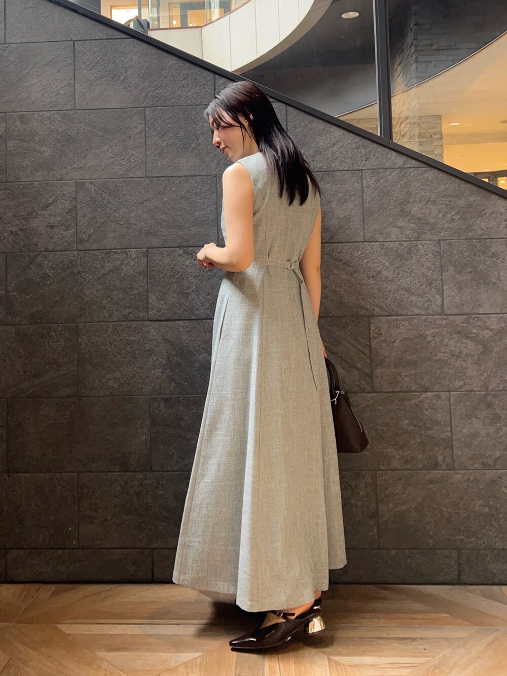 ブルー系のワンピース、ブラウン系のパンプス、ブラウン系のボストンバッグを着用したレディースの夏コーディネートの2枚目の写真