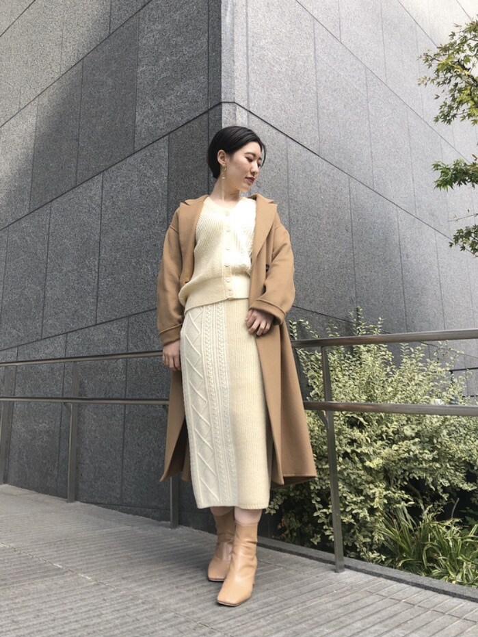 ベージュ系のその他アウター、ピンク系のスカート、ゴールド系のピアス（両耳用）を着用したレディースの冬コーディネートの4枚目の写真