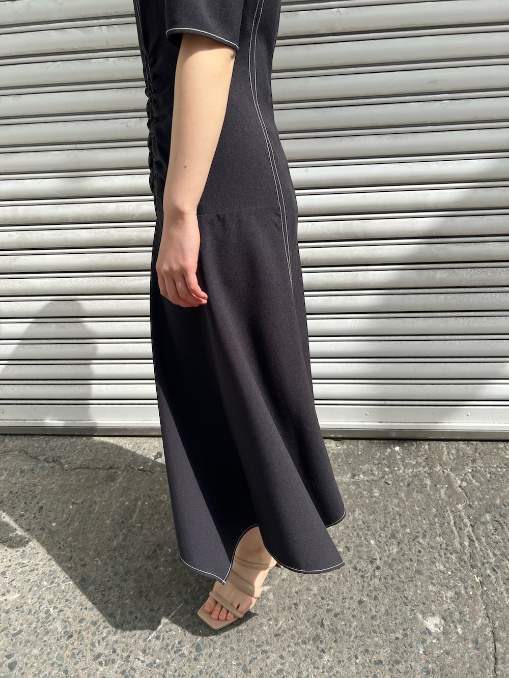 ベージュ系のサンダル、ブラック系のワンピース、ベージュ系のテーラードジャケットを着用したレディースの春コーディネートの8枚目の写真