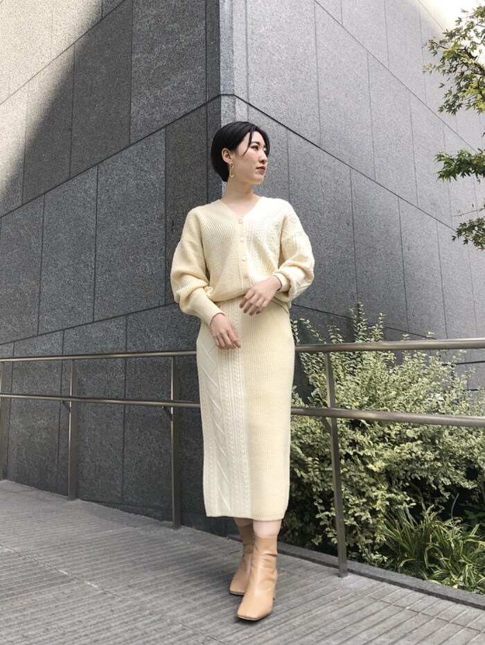 ベージュ系のその他アウター、ピンク系のスカート、ゴールド系のピアス（両耳用）を着用したレディースの冬コーディネートの3枚目の写真