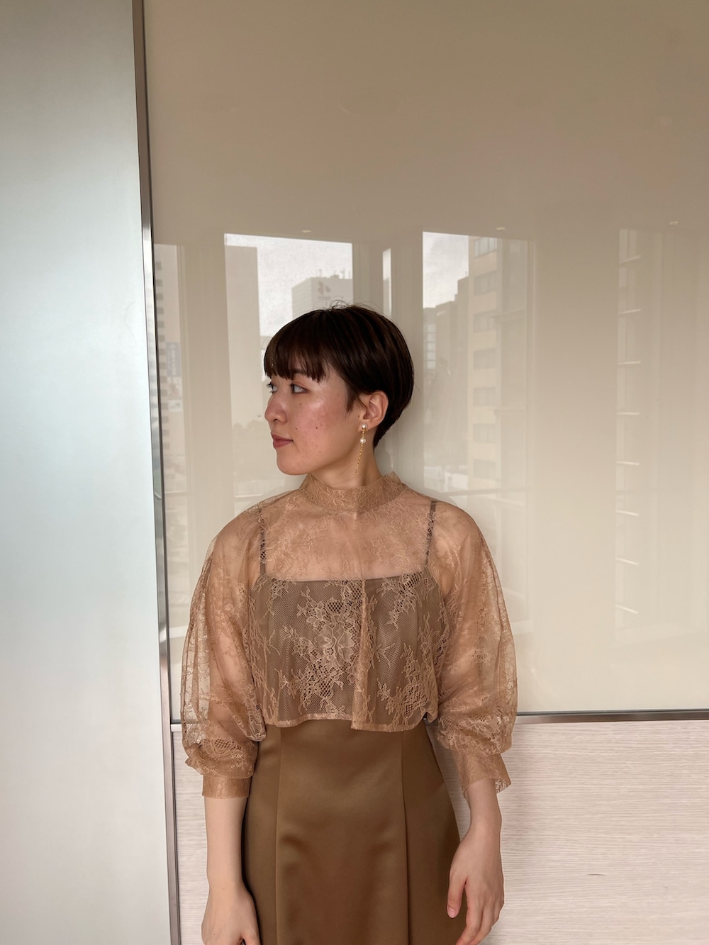 ベージュ系のクラッチバッグ、ブラウン系のドレス、ベージュ系のパンプスを着用したレディースの夏コーディネートの3枚目の写真