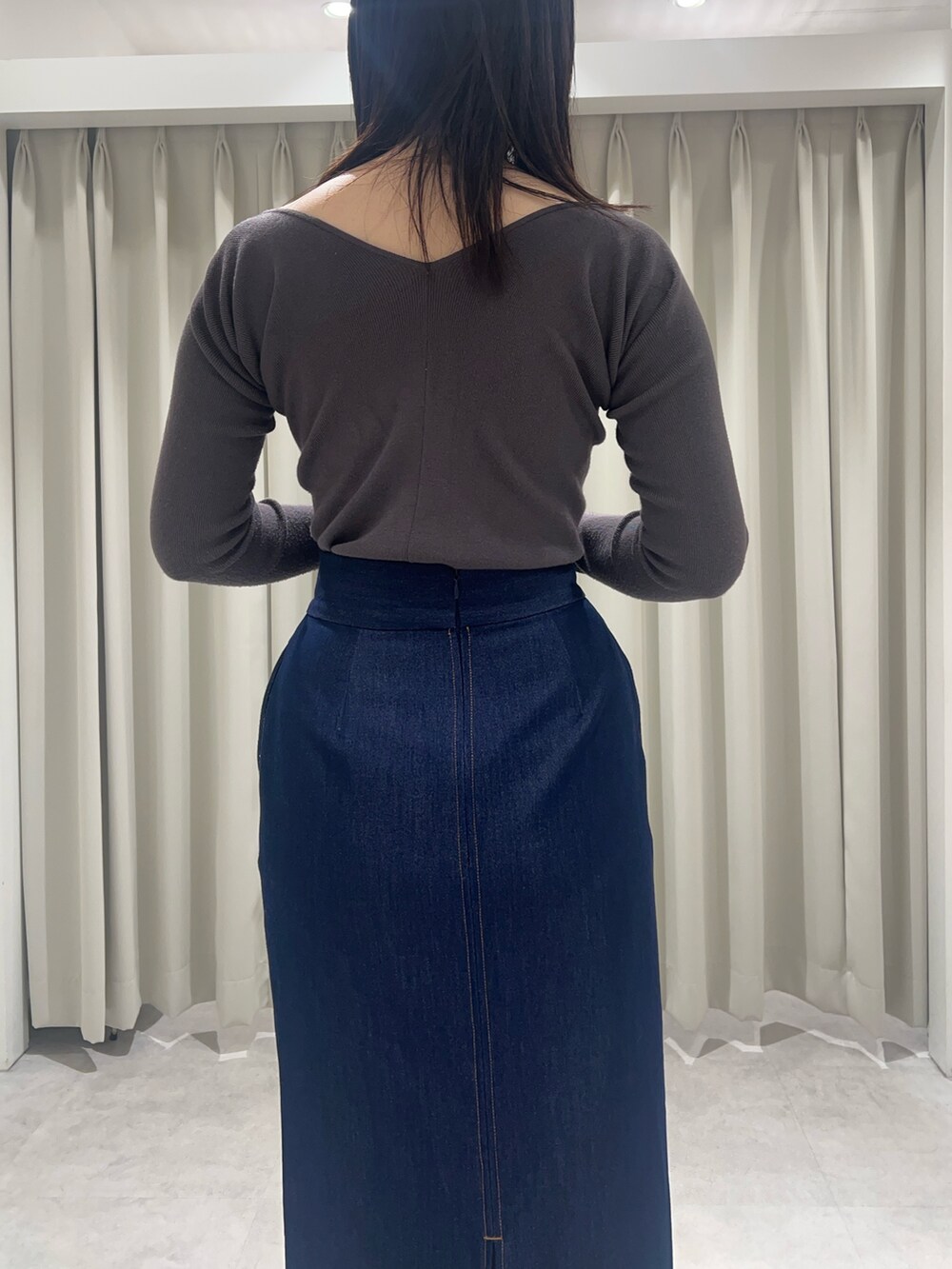 ブルー系のスカート、グレー系のニット/セーターを着用したレディースの春コーディネートの5枚目の写真