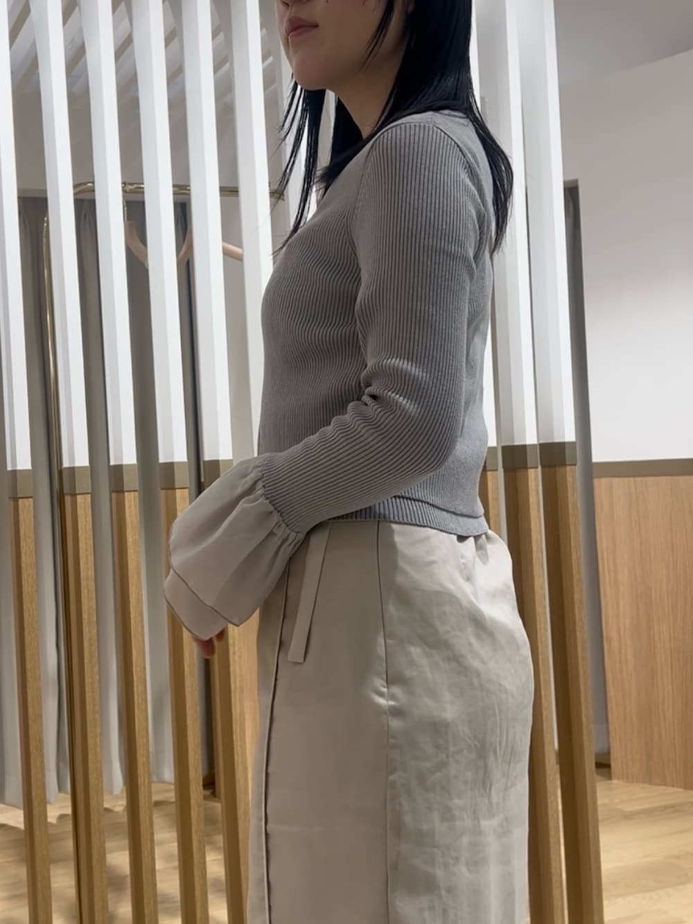 ホワイト系のスカート、グレー系のアンサンブル、ホワイト系のサンダルを着用したレディースの春コーディネートの5枚目の写真