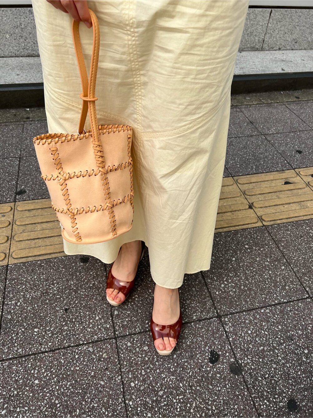 ブルー系のトレンチコート、ブラック系のワンピース、ブラウン系のパンプスを着用したレディースの春コーディネートの10枚目の写真