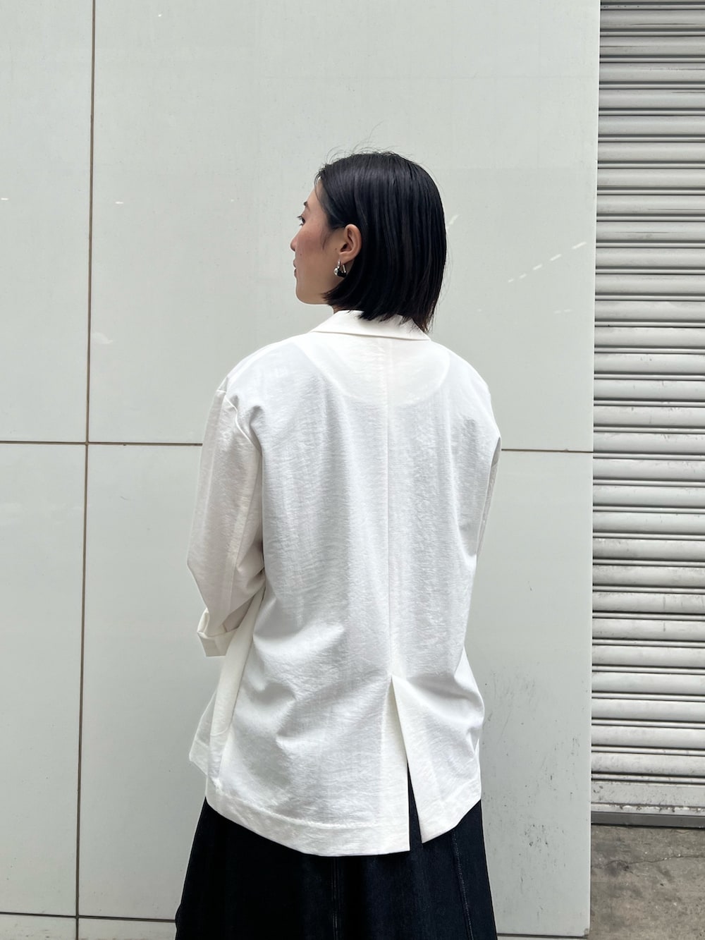 ブラック系のワンピース、ブラック系のサンダル、ブラック系のハンドバッグを着用したレディースの春コーディネートの3枚目の写真