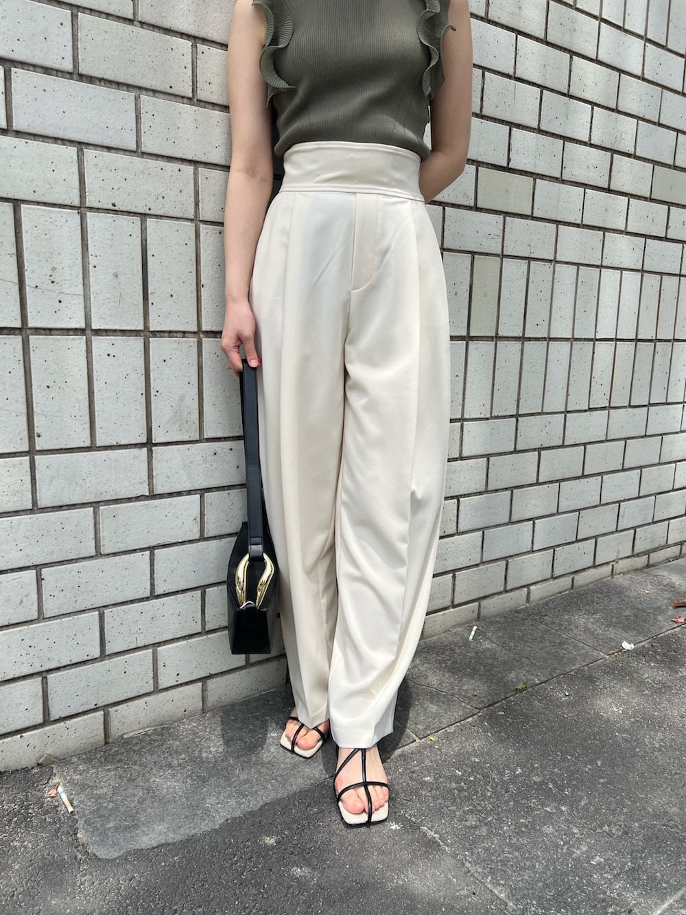 グリーン系のニット/セーター、ホワイト系のその他パンツ、ブラック系のサンダルを着用したレディースの春コーディネートの5枚目の写真