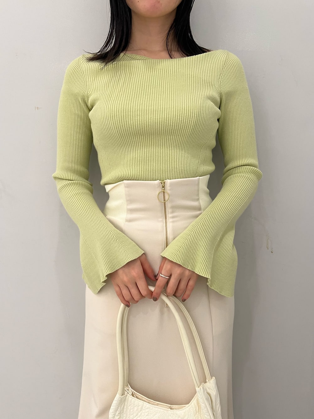 グリーン系のニット/セーター、ホワイト系のスカートを着用したレディースの冬コーディネートの5枚目の写真