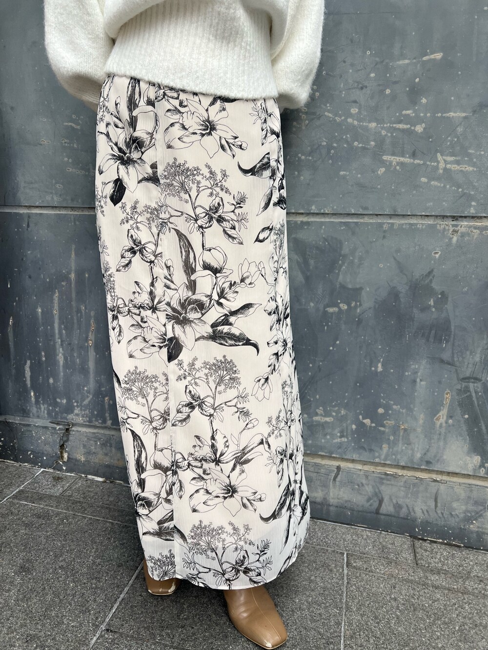 ベージュ系のブーツ、ブルー系のショルダーバッグ、ホワイト系のスカートを着用したレディースの冬コーディネートの7枚目の写真