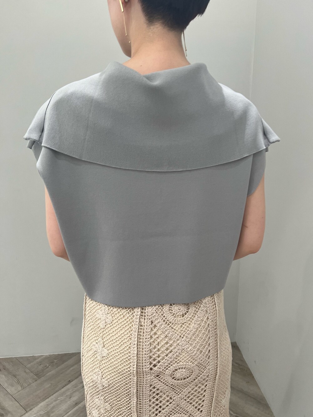 ベージュ系のサンダル、ブラック系のハンドバッグ、ブルー系のニット/セーターを着用したレディースの春コーディネートの5枚目の写真