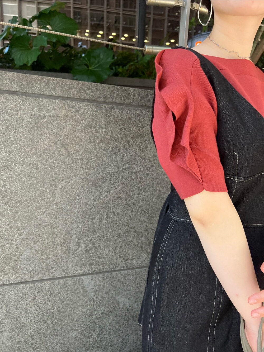 ベージュ系のハンドバッグ、ブラック系のワンピース、オレンジ系のニット/セーターを着用したレディースの夏コーディネートの4枚目の写真