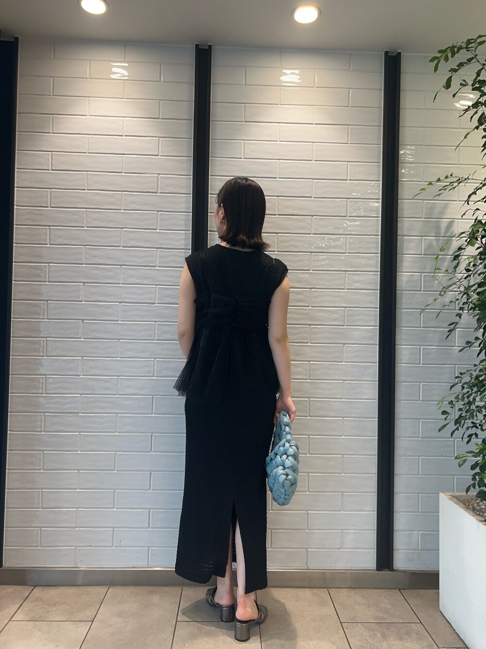 その他のサンダル、ブラック系のワンピース、ブルー系のハンドバッグを着用したレディースの夏コーディネートの3枚目の写真