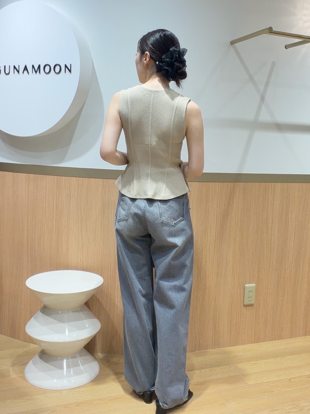 ベージュ系のニット/セーター、グレー系のデニムパンツ、ブラック系のサンダルを着用したレディースの春コーディネートの2枚目の写真