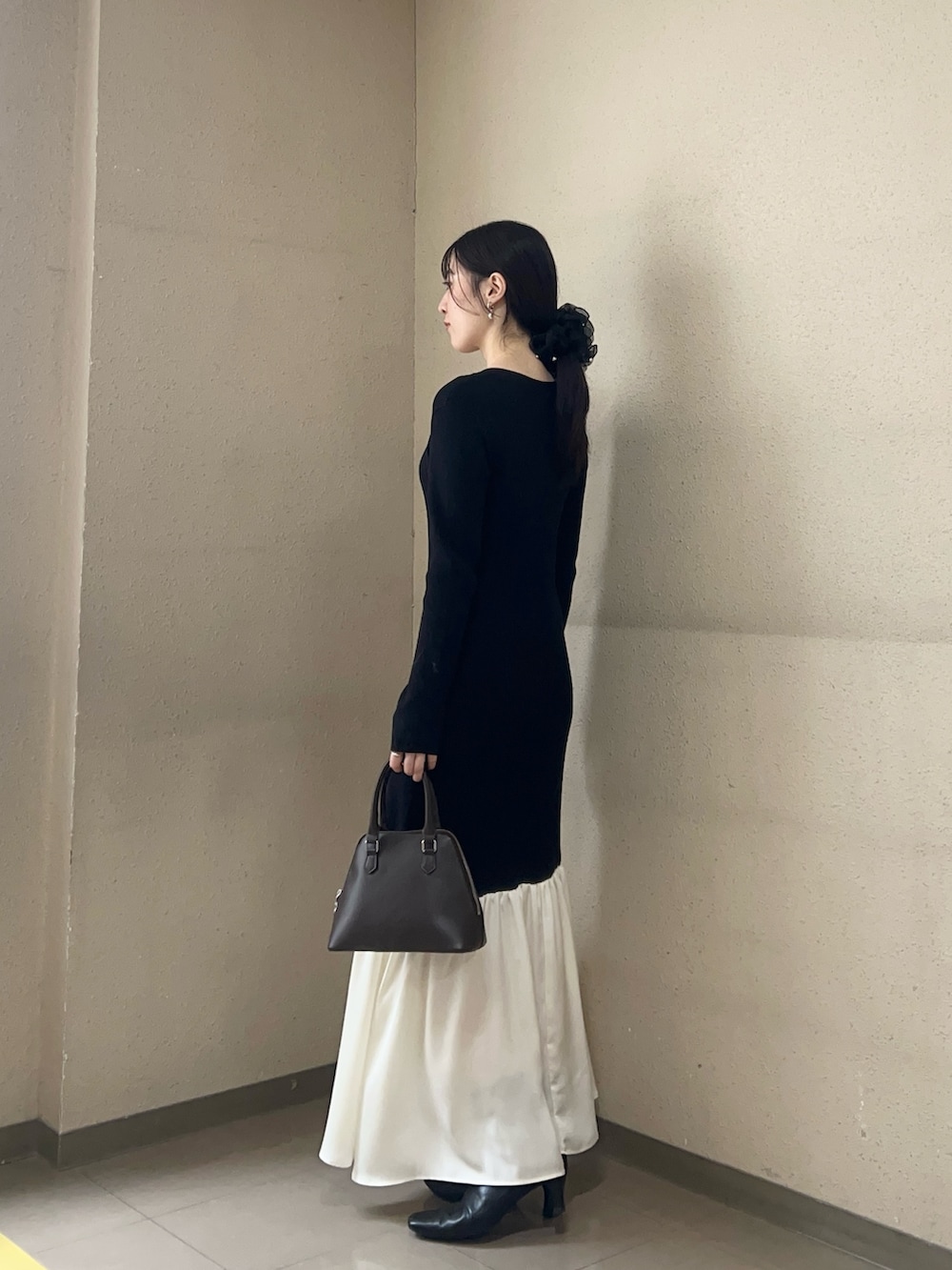 ブラック系のワンピース、ブラック系のブーツを着用したレディースの冬コーディネートの2枚目の写真