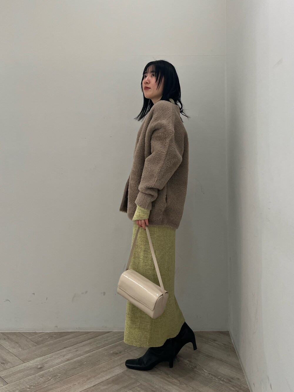 ブラウン系のカーディガン/ボレロ、グリーン系のワンピースを着用したレディースの冬コーディネートの2枚目の写真
