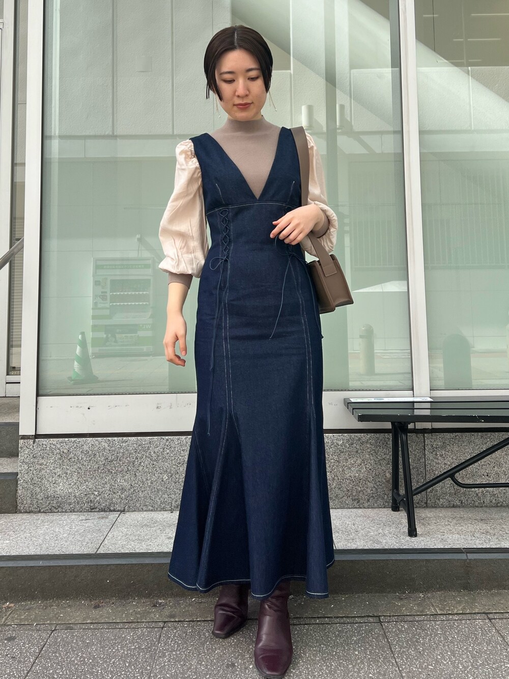 ベージュ系のカーディガン/ボレロ、レッド系のブーツ、ブラウン系のニット/セーターを着用したレディースの冬コーディネートの2枚目の写真