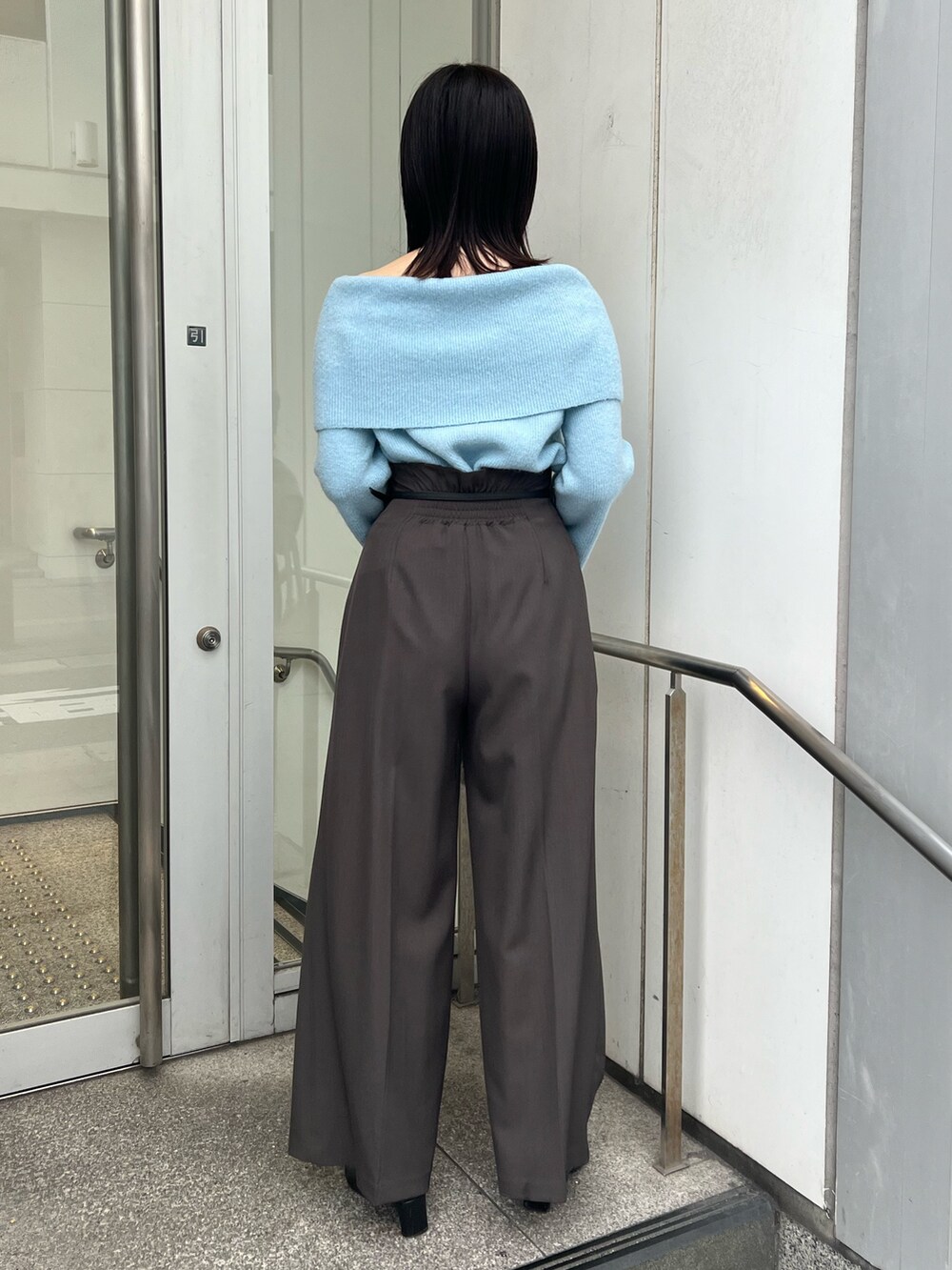 ブルー系のニット/セーター、グレー系のその他パンツ、ブラック系のブーツを着用したレディースの秋コーディネートの2枚目の写真