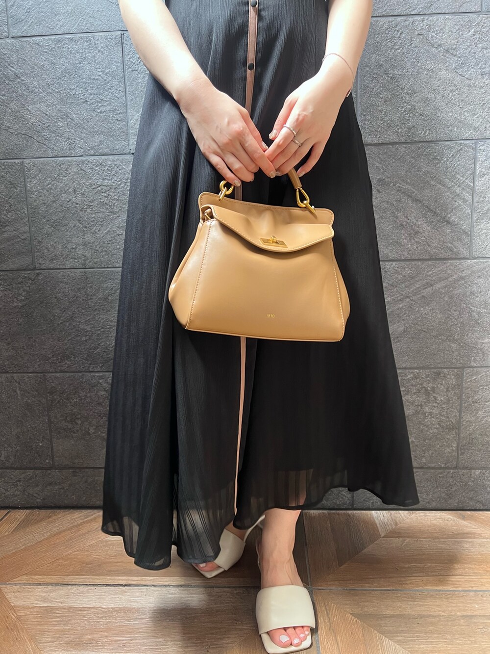 ブラック系のワンピース、ホワイト系のサンダル、レッド系のハンドバッグを着用したレディースの夏コーディネートの7枚目の写真