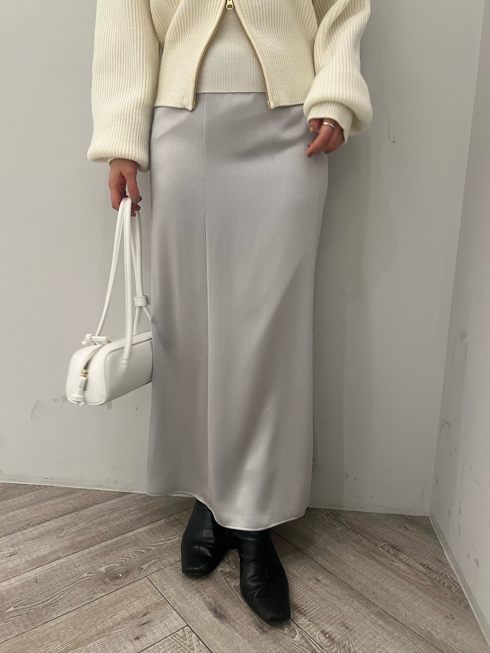 ホワイト系のニット/セーター、グレー系のスカートを着用したレディースの冬コーディネートの6枚目の写真