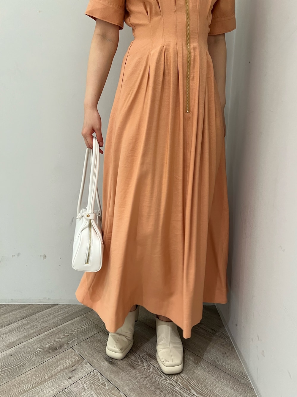 オレンジ系のワンピース、ホワイト系のサンダルを着用したレディースの春コーディネートの7枚目の写真