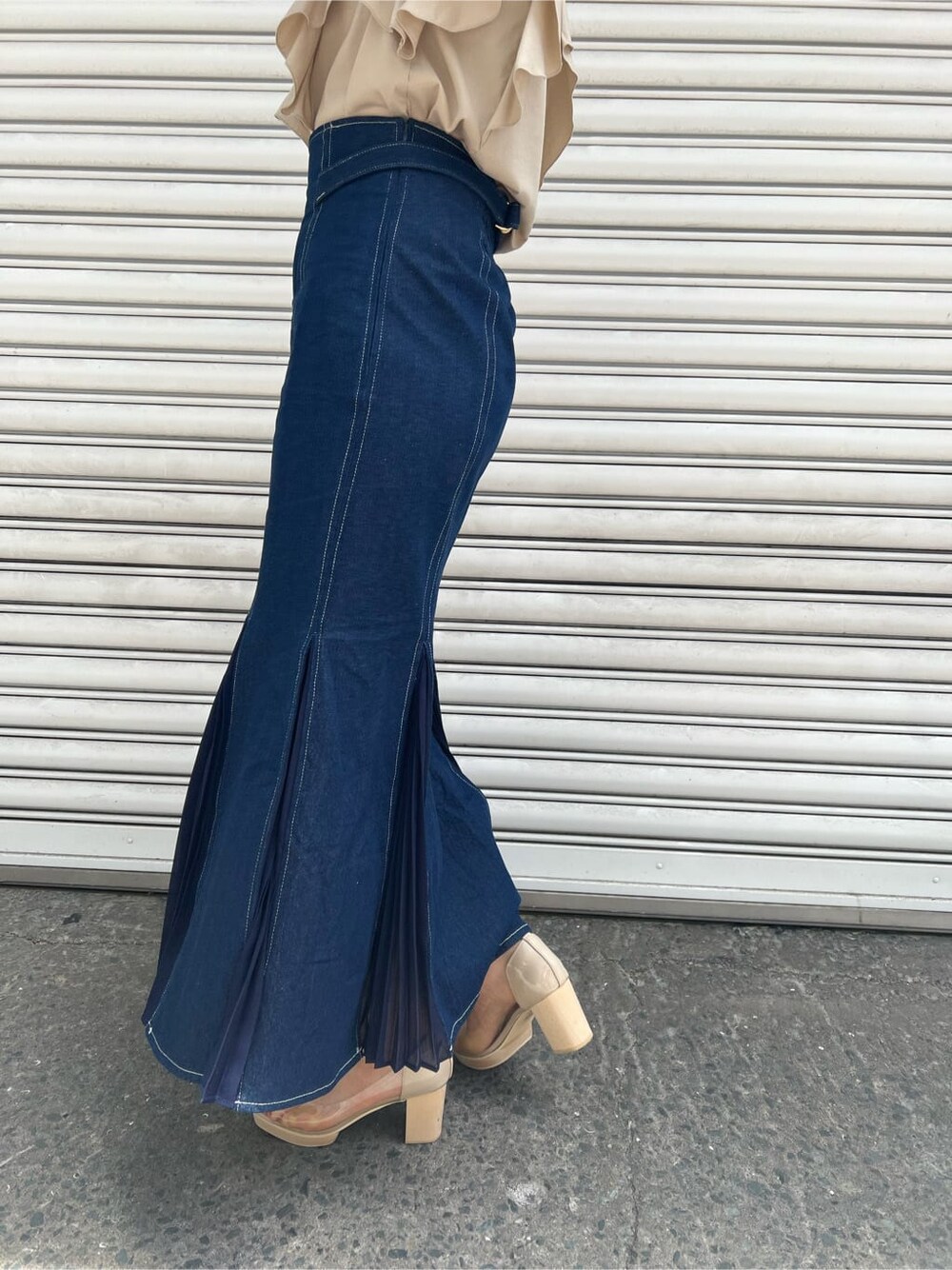 ベージュ系のハンドバッグ、ブルー系のスカート、その他のパンプスを着用したレディースの春コーディネートの6枚目の写真