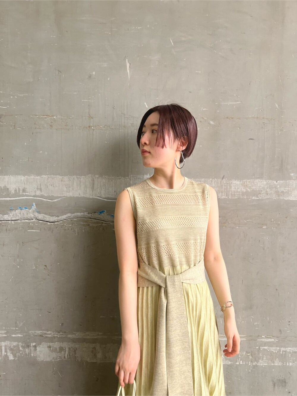 ホワイト系のハンドバッグ、ベージュ系のサンダル、グリーン系のワンピースを着用したレディースの夏コーディネートの2枚目の写真