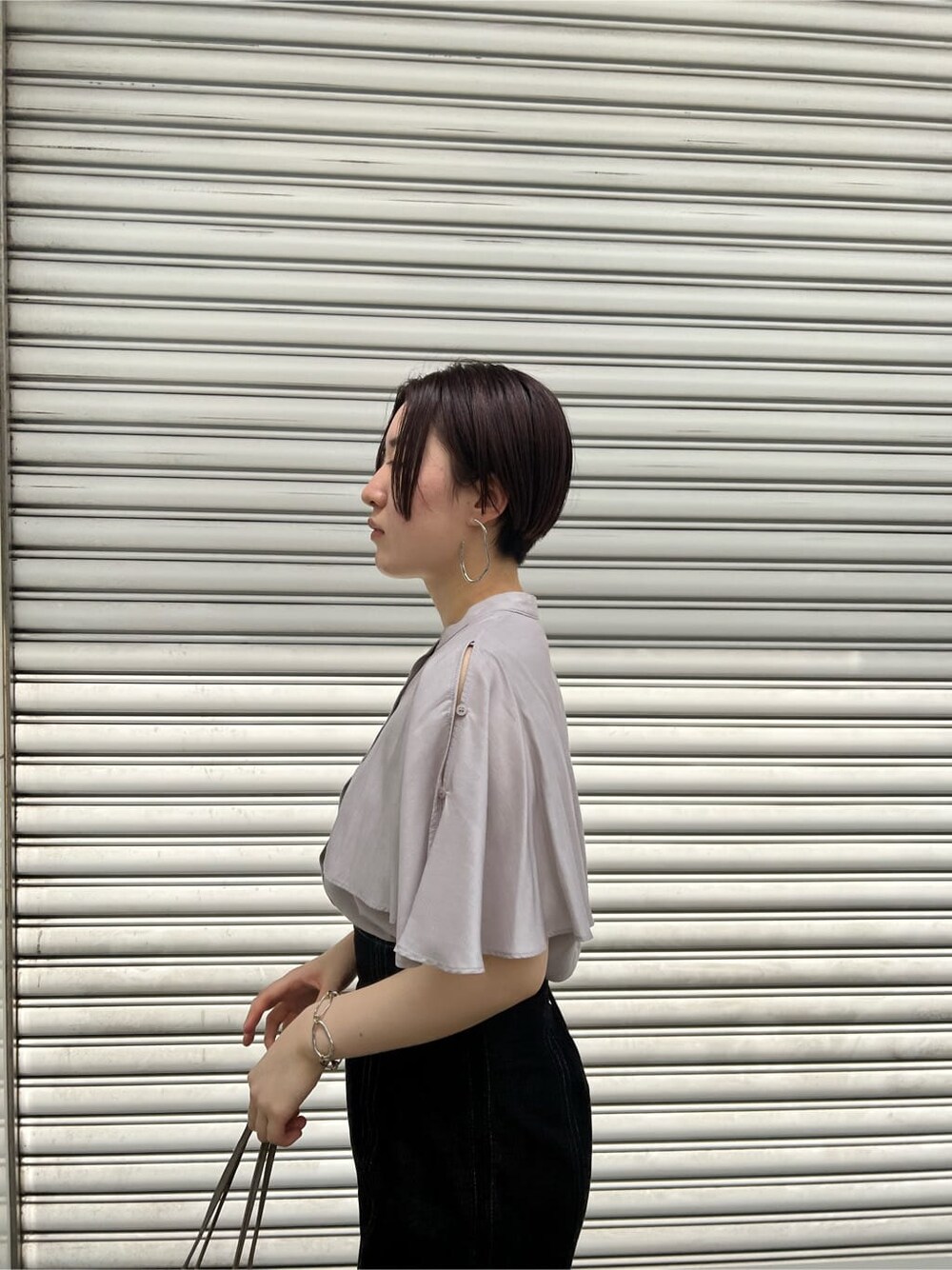 ベージュ系のハンドバッグ、ブラック系のスカート、その他のサンダルを着用したレディースの夏コーディネートの4枚目の写真