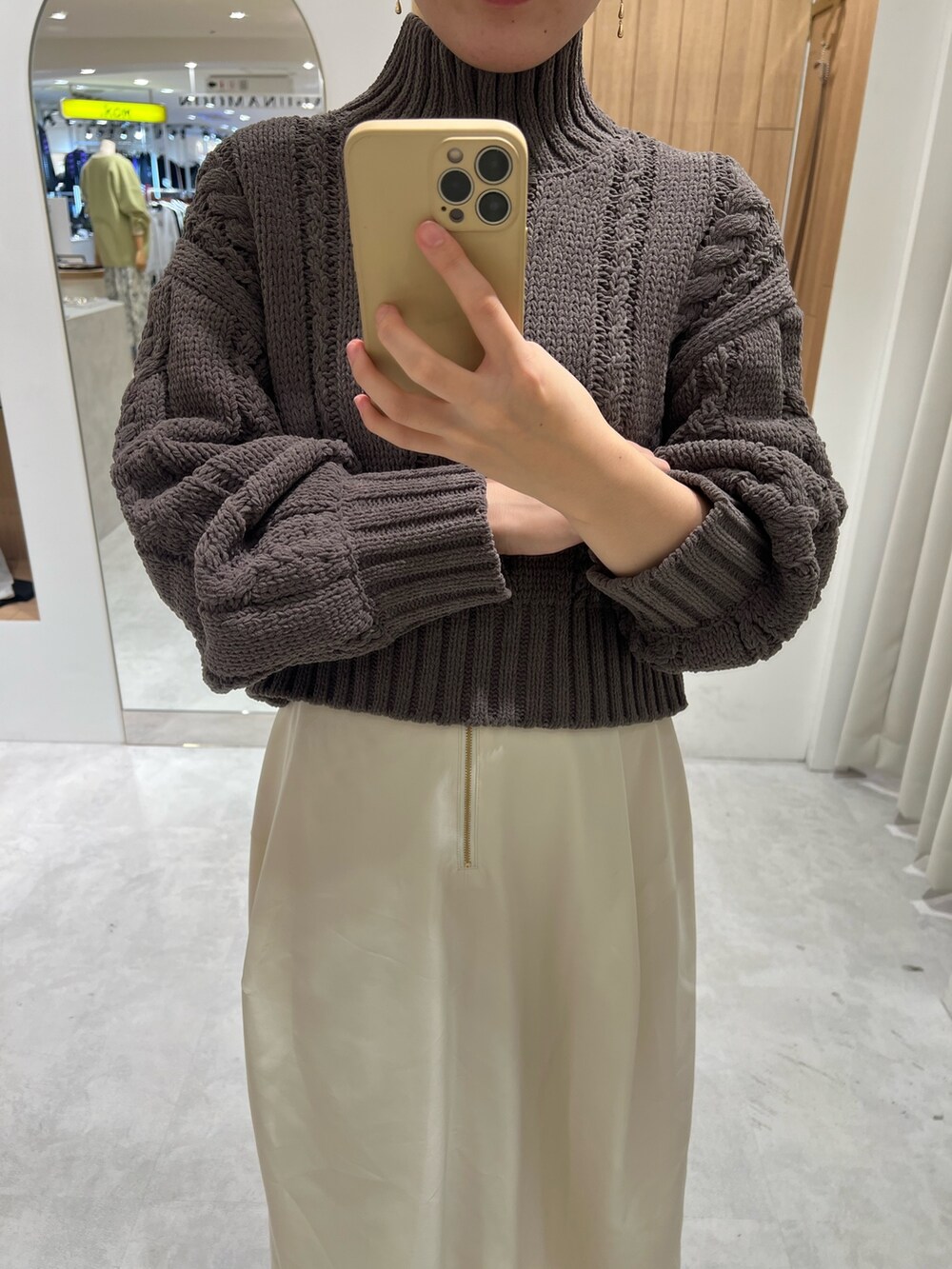 ホワイト系のスカート、グレー系のニット/セーター、ベージュ系のブーツを着用したレディースの秋コーディネートの3枚目の写真