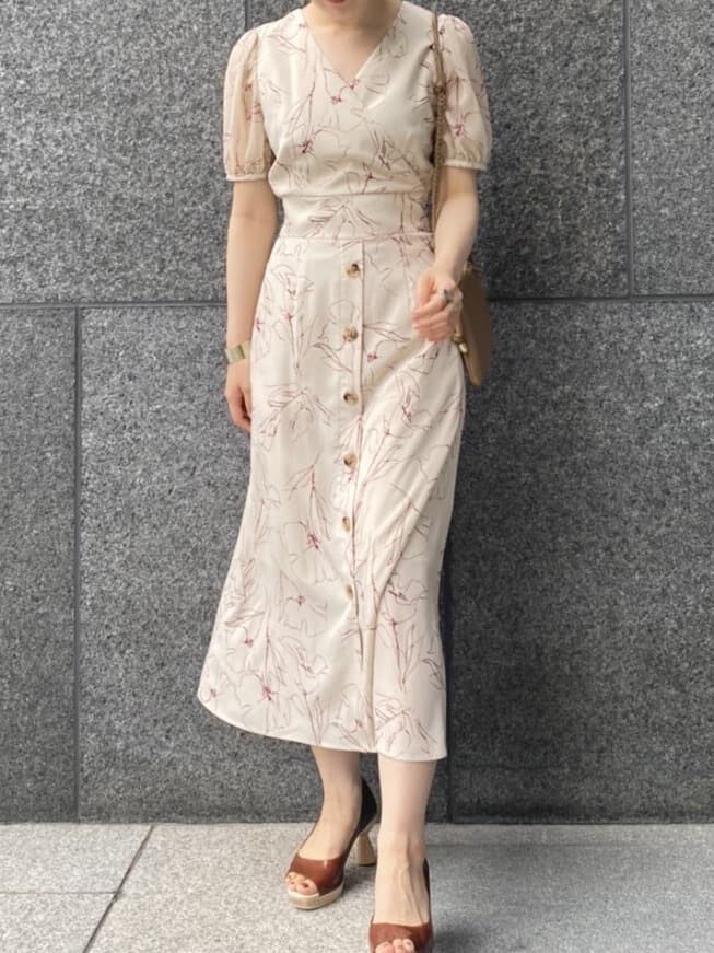 ブラウン系のパンプス、ベージュ系のショルダーバッグ、ホワイト系のワンピースを着用したレディースの夏コーディネートの2枚目の写真