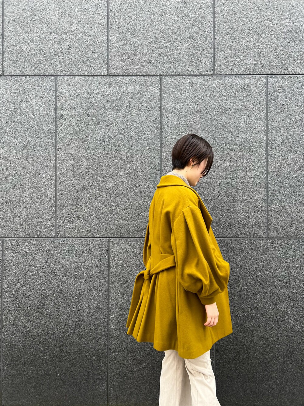 ホワイト系のその他シューズ、イエロー系のその他アウター、ベージュ系のその他パンツを着用したレディースの秋コーディネートの2枚目の写真