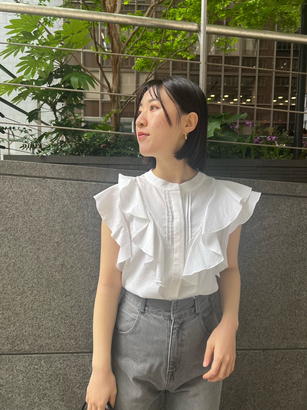 シルバー系のパンプス、グレー系のデニムパンツ、ホワイト系のシャツ/ブラウスを着用したレディースの春コーディネートの3枚目の写真