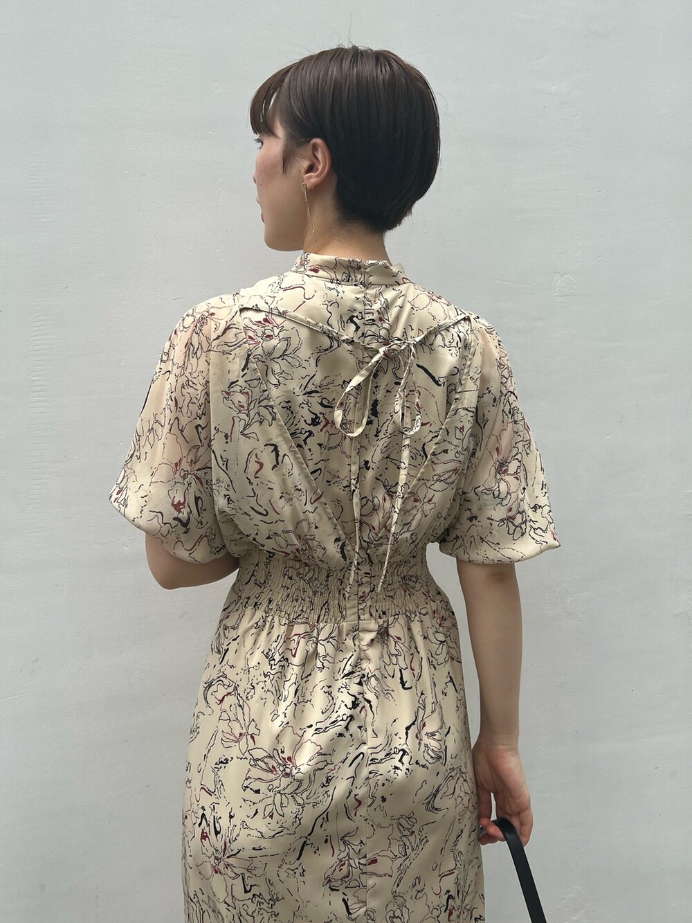 ブラック系のハンドバッグ、その他のサンダル、ベージュ系のワンピースを着用したレディースの夏コーディネートの5枚目の写真