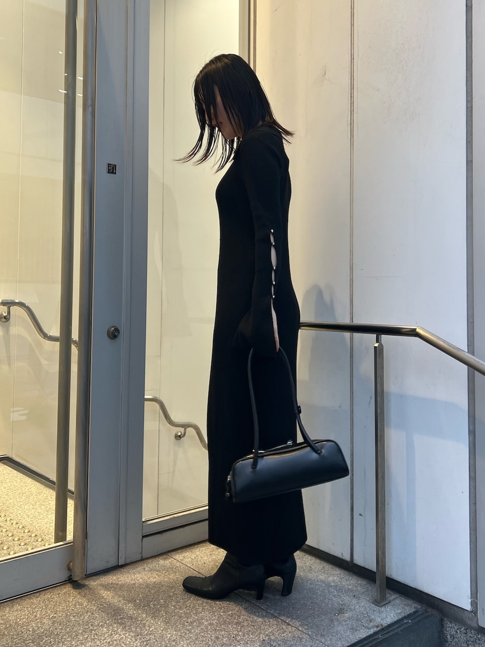 ブラック系のワンピース、ブラウン系のカーディガン/ボレロ、ブラック系のブーツを着用したレディースの冬コーディネートの4枚目の写真