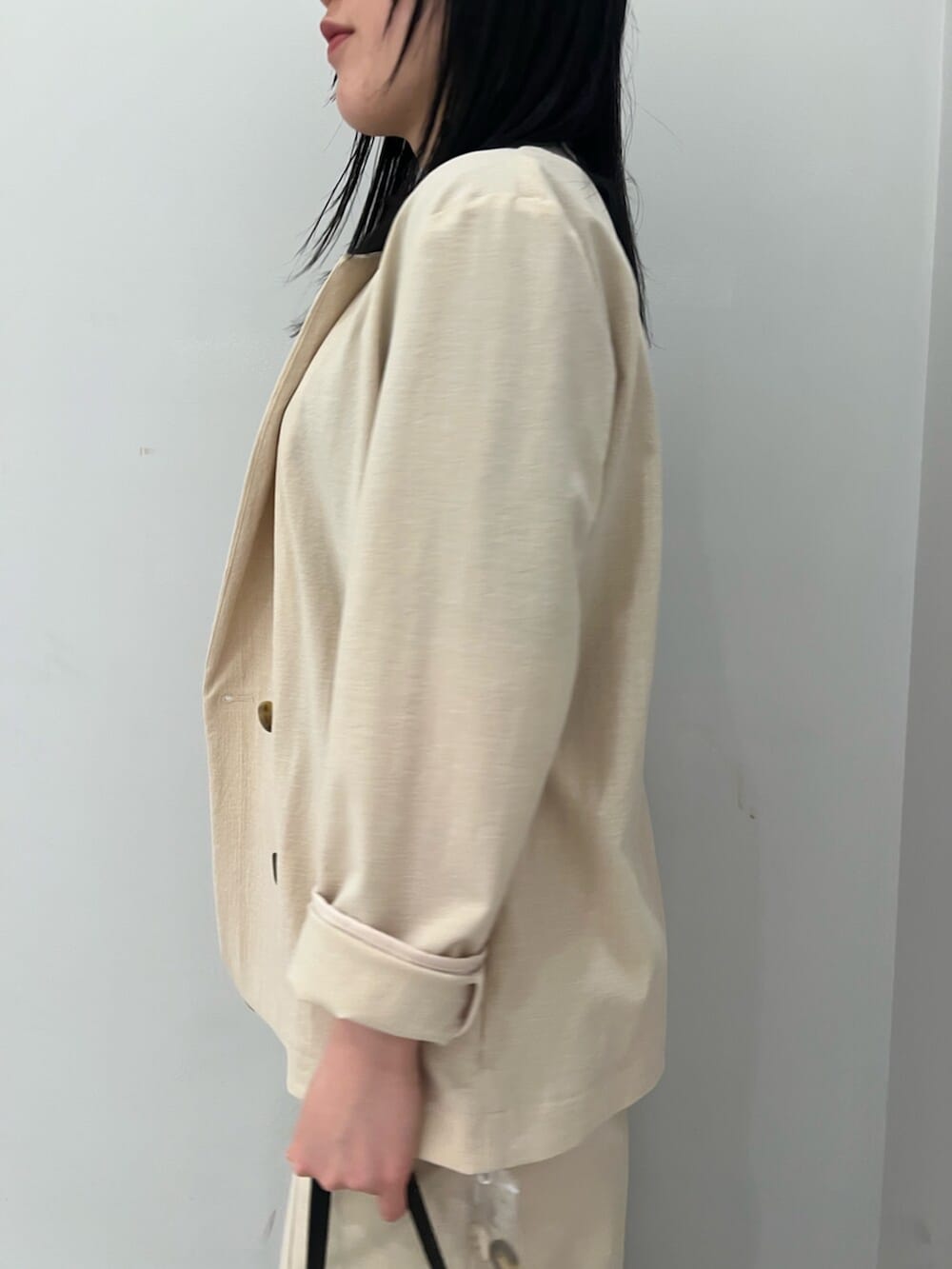 ブルー系のニット/セーター、ホワイト系のサンダル、ベージュ系のテーラードジャケットを着用したレディースの春コーディネートの5枚目の写真