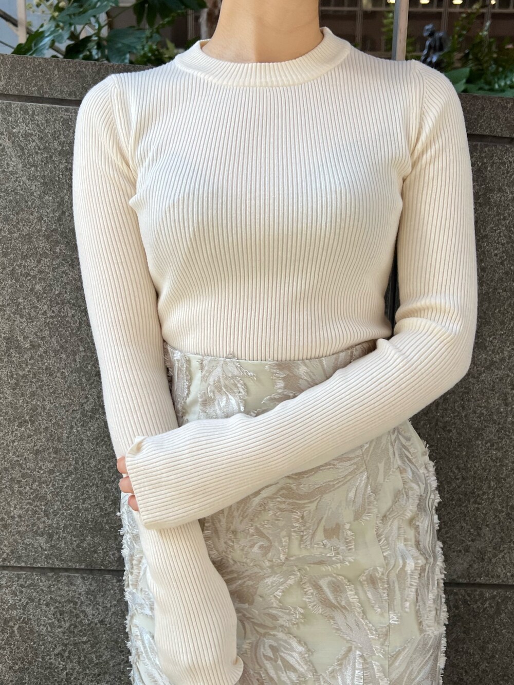 グレー系のカーディガン/ボレロ、ベージュ系のスカート、ホワイト系のニット/セーターを着用したレディースの冬コーディネートの5枚目の写真