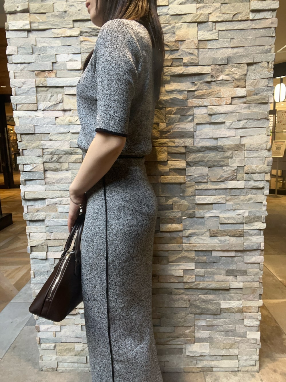 ブラック系のワンピース、ブラック系のブーツ、ブラウン系のボストンバッグを着用したレディースの夏コーディネートの5枚目の写真