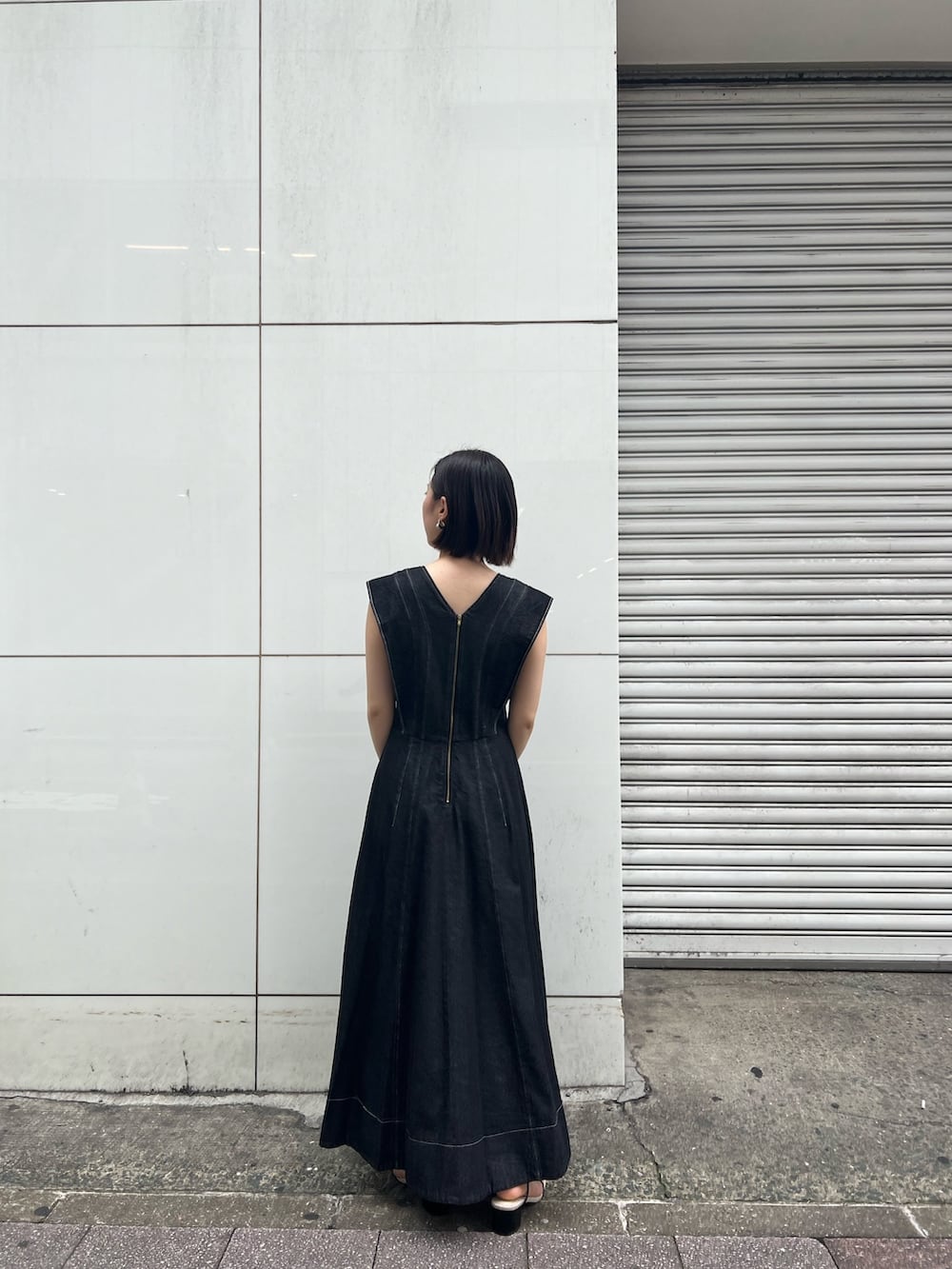 ブラック系のワンピース、ブラック系のサンダル、ブラック系のハンドバッグを着用したレディースの春コーディネートの6枚目の写真