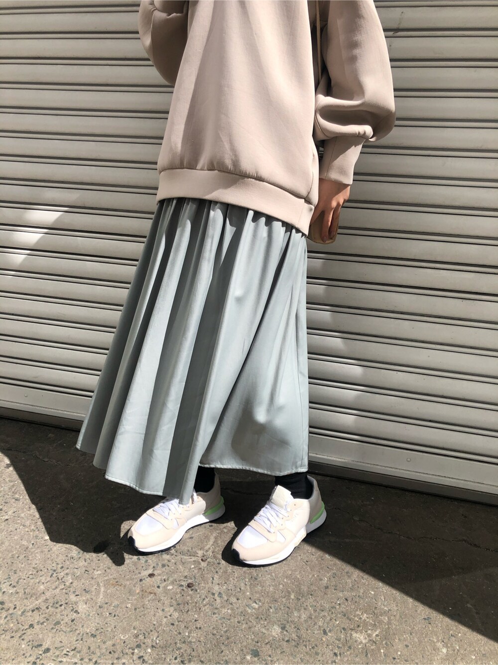 ホワイト系のスニーカー、ベージュ系のTシャツ/カットソー、グリーン系のワンピースを着用したレディースの春コーディネートの2枚目の写真