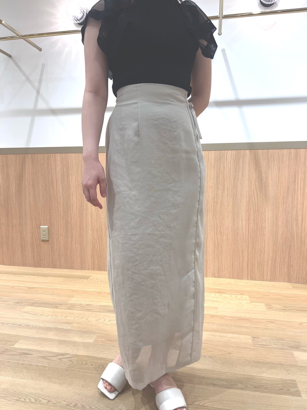 ブラック系のニット/セーター、ホワイト系のスカート、ホワイト系のサンダルを着用したレディースの春コーディネートの7枚目の写真