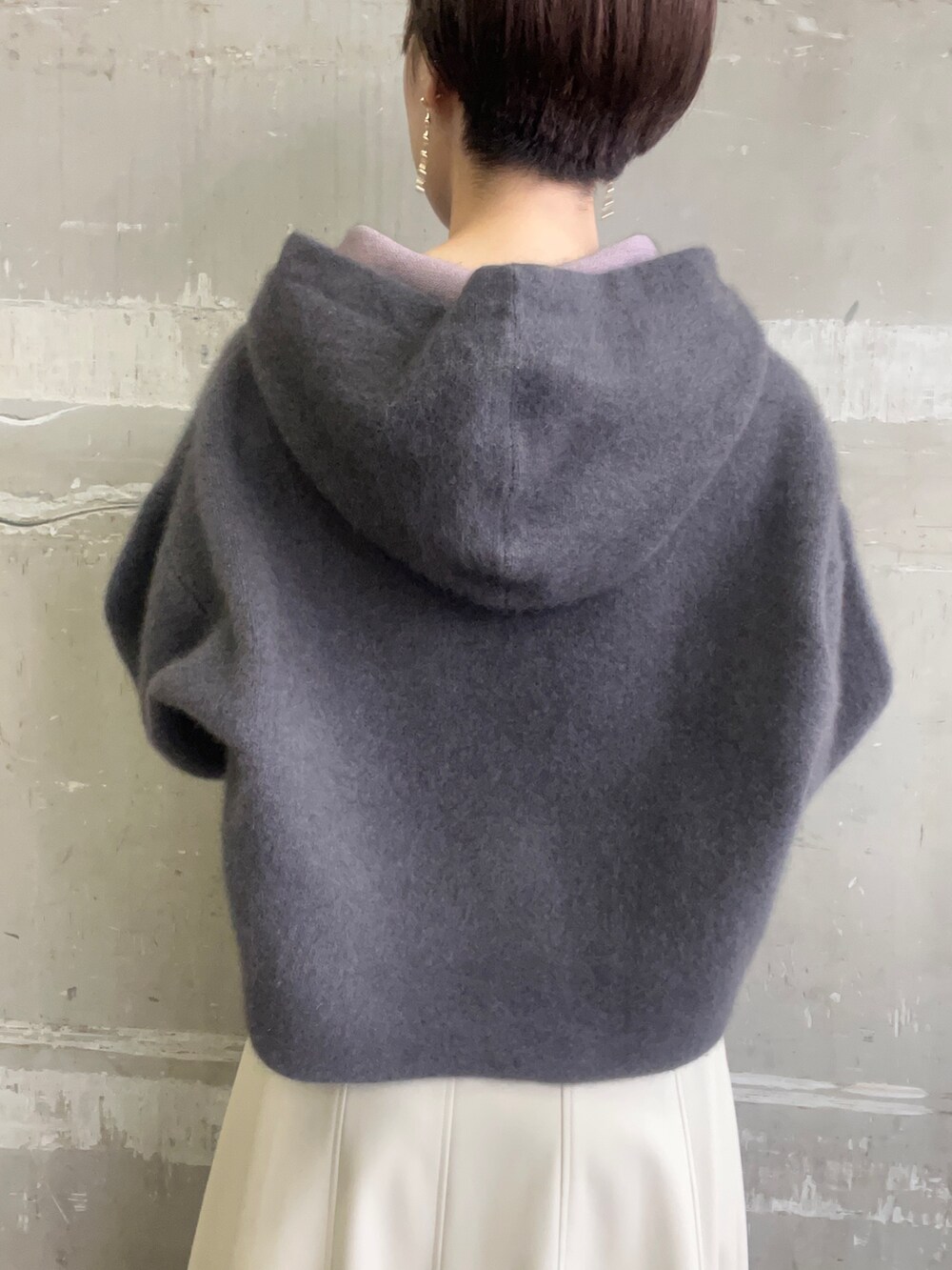 ベージュ系のブーツ、グレー系のパーカー、ホワイト系のスカートを着用したレディースの秋コーディネートの6枚目の写真