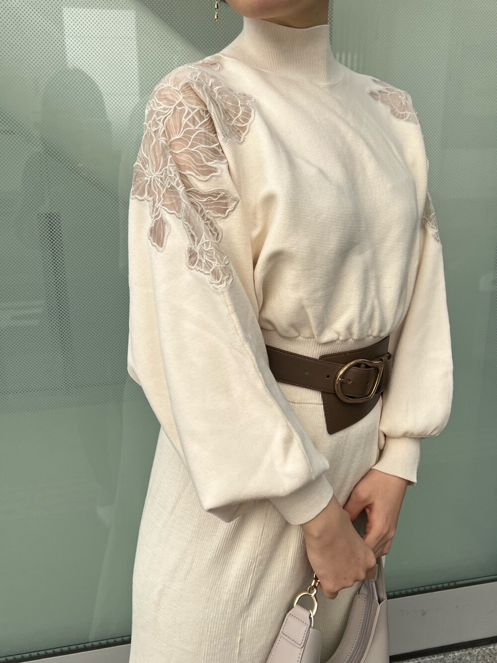 ホワイト系のハンドバッグ、ベージュ系のブーツ、ホワイト系のワンピースを着用したレディースの冬コーディネートの6枚目の写真